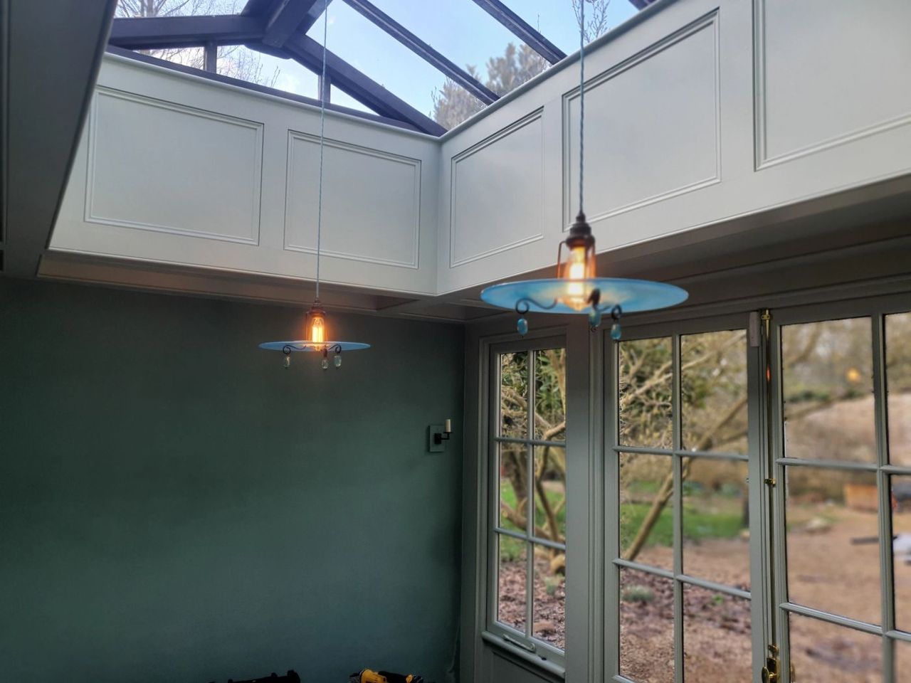 Pendant lighting under a glazed lantern roof in a conservatory