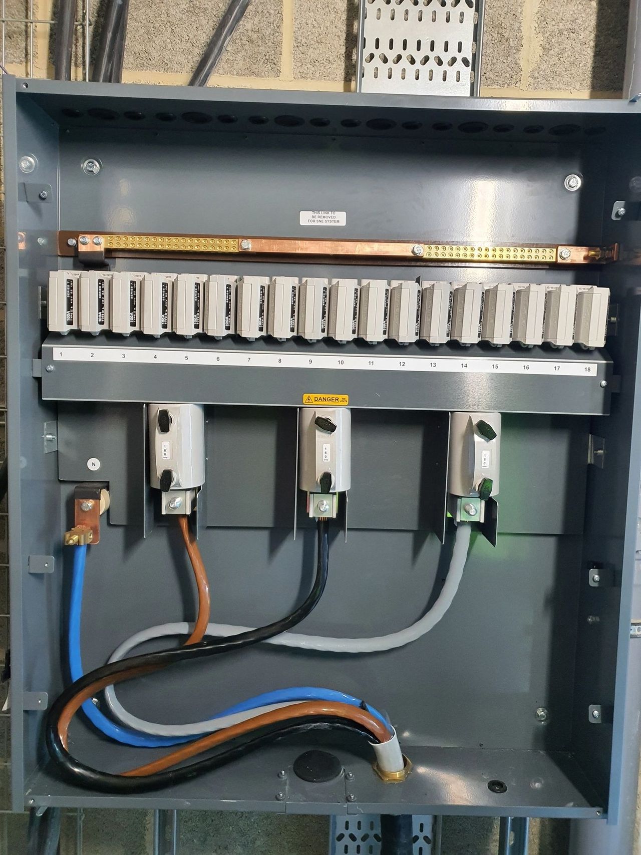 Commercial distribution board with a row of breakers on a copper busbar