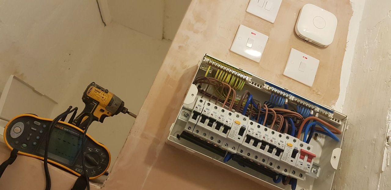 BES Electric electrician fitting a consumer unit with an impact driver